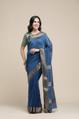 Woman wearing a blue saree with a beige background