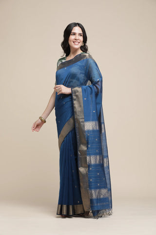 Woman wearing a blue saree with a beige background