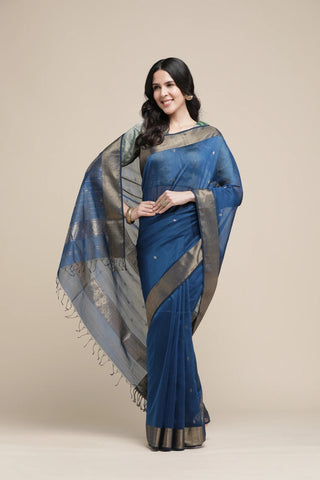 Woman wearing a blue saree with a beige background