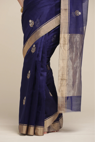 Navy blue saree with gold border on a beige background