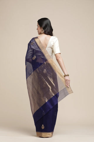 Woman wearing a traditional saree with a plain background