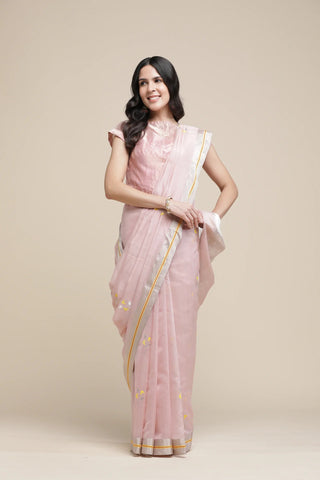 Woman wearing a pink saree with a plain background