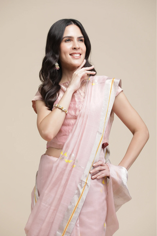 Woman wearing a pink saree with a beige background