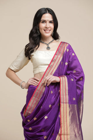 Woman wearing a purple saree with a beige background