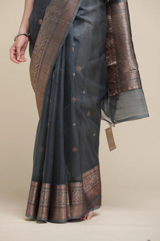 Black saree with brown border on a beige background