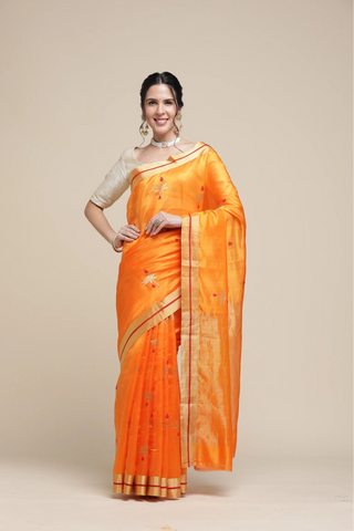 Woman wearing an orange saree with a beige background