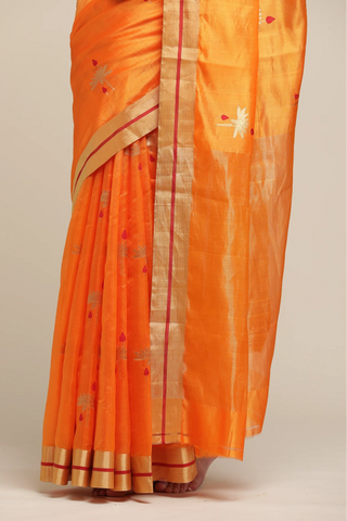 Orange saree with gold and red border on a plain background