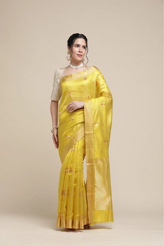 Woman wearing a yellow saree with a beige background