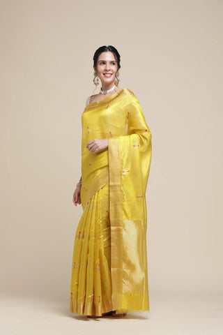 Woman wearing a yellow saree with a plain background
