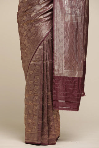 Brown saree with leaf patterns on a beige background