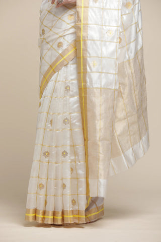 White saree with yellow patterns on a beige background