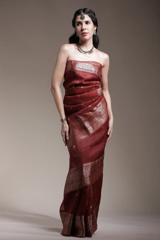 Woman wearing a red strapless dress against a plain background