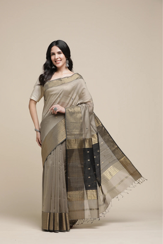 Woman wearing a traditional saree with a plain background