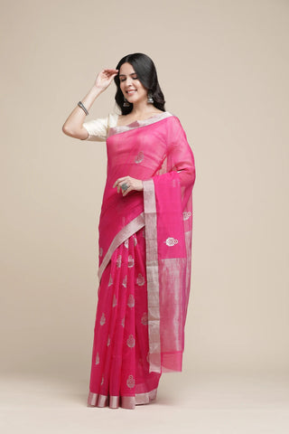 Woman wearing a pink saree with a white blouse against a beige background