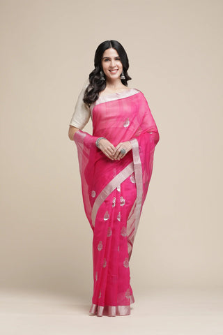 Woman wearing a pink saree with a white blouse against a beige background