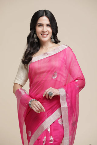 Woman wearing a pink saree with a beige background
