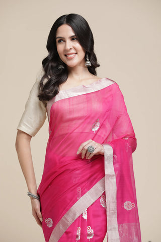 Woman wearing a pink saree with a beige blouse against a beige background