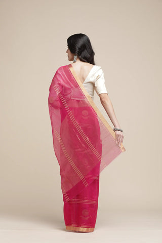 Woman wearing a pink saree with a white blouse against a beige background