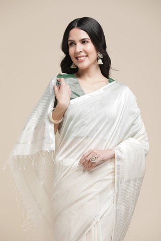 Woman wearing a white saree with a beige background
